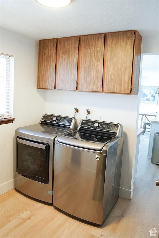 431 E Hooper Ave, Soda Springs, ID 83276 - washroom featuring cabinet space, separate washer and dryer, light wood-type flooring, and plenty of natural light