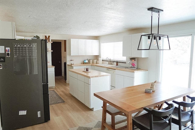 431 E Hooper Ave, Soda Springs, ID 83276 - kitchen featuring freestanding refrigerator, light wood finished floors, a sink, white cabinetry, and dishwasher