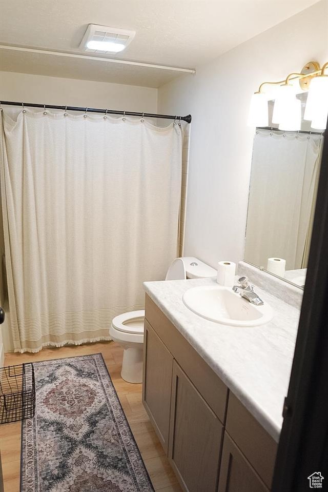 431 E Hooper Ave, Soda Springs, ID 83276 - full bath featuring toilet, vanity, wood finished floors, and a shower with curtain