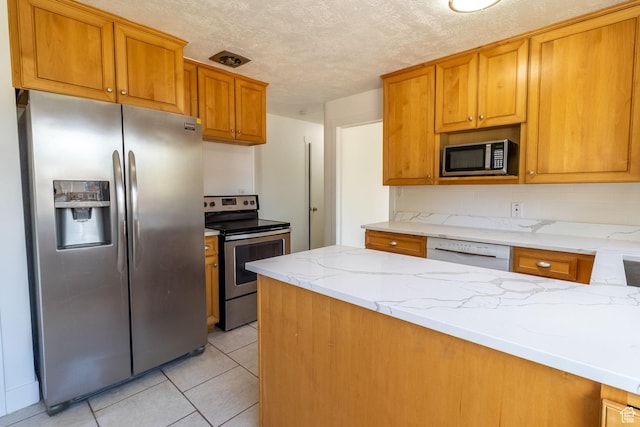 2079 W 3900 S, Roy, UT 84067 - kitchen with appliances with stainless steel finishes, light stone counters, light tile patterned floors, brown cabinets, and a textured ceiling