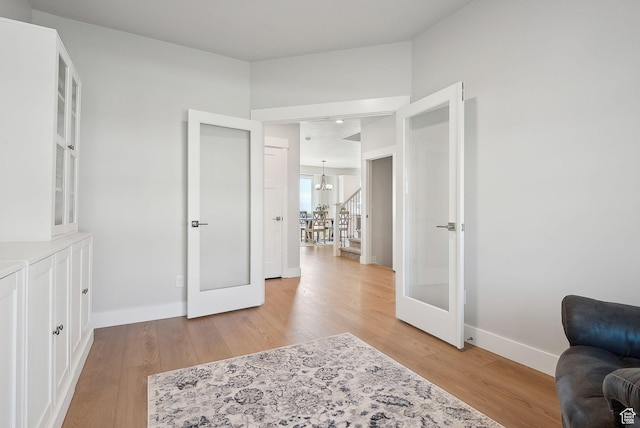 13321 S Split Oak Dr, Herriman, UT 84096 - bedroom featuring french doors, a chandelier, light wood finished floors, and baseboards