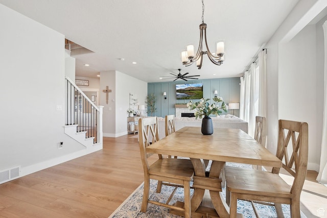 13321 S Split Oak Dr, Herriman, UT 84096 - dining room featuring a chandelier, light wood-type flooring, stairway, a ceiling fan, and baseboards