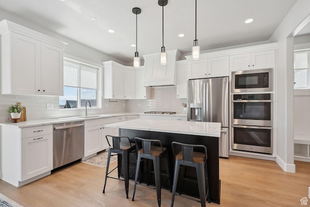 13321 S Split Oak Dr, Herriman, UT 84096 - kitchen featuring stainless steel appliances, custom range hood, light wood-style flooring, white cabinets, and recessed lighting