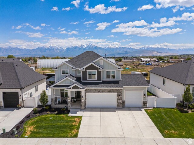 13321 S Split Oak Dr, Herriman, UT 84096 - view of front facade with board and batten siding, a mountain view, covered porch, and concrete driveway