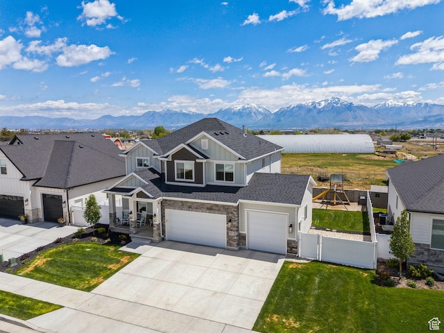 13321 S Split Oak Dr, Herriman, UT 84096 - view of front of property with board and batten siding, a mountain view, stone siding, concrete driveway, and a gate