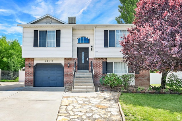 1240 N 2525 W, Layton, UT 84041 - bi-level home with brick siding, driveway, an attached garage, and a front lawn