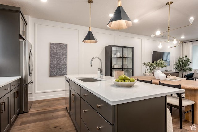 937 W Coalburn Way Unit 102, Murray, UT 84123 - kitchen with a sink, a decorative wall, appliances with stainless steel finishes, a center island with sink, and dark wood-style floors