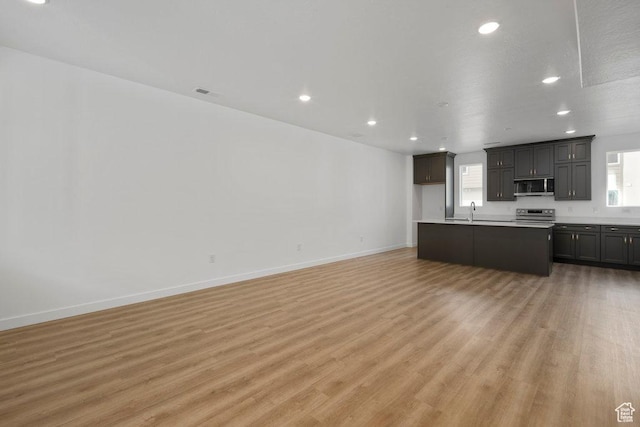 937 W Coalburn Way Unit 102, Murray, UT 84123 - unfurnished living room with light wood-type flooring, recessed lighting, baseboards, and a sink