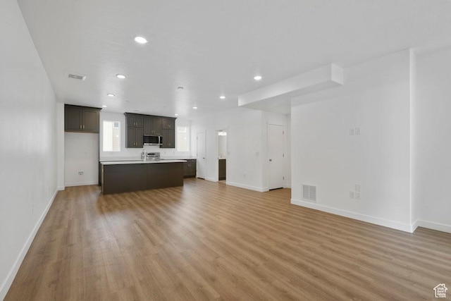 937 W Coalburn Way Unit 102, Murray, UT 84123 - unfurnished living room with recessed lighting, light wood finished floors, and baseboards
