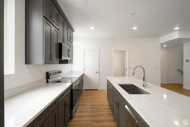 937 W Coalburn Way Unit 102, Murray, UT 84123 - kitchen featuring stainless steel appliances, a sink, light wood-style floors, light stone countertops, and recessed lighting
