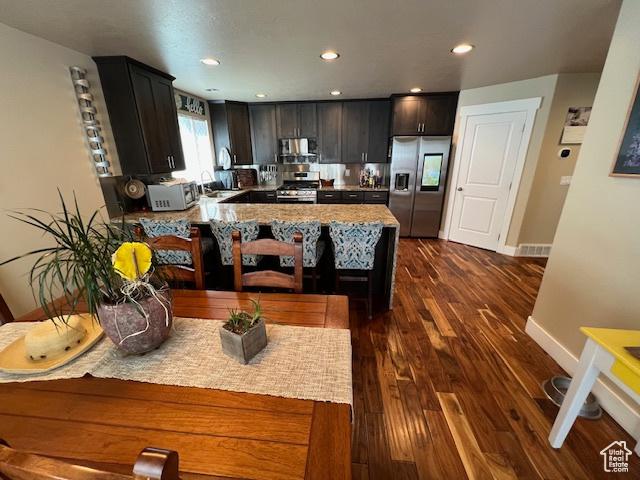 115 E 8469 S, Sandy, UT 84070 - kitchen featuring stainless steel appliances, dark wood-type flooring, a peninsula, baseboards, and a sink