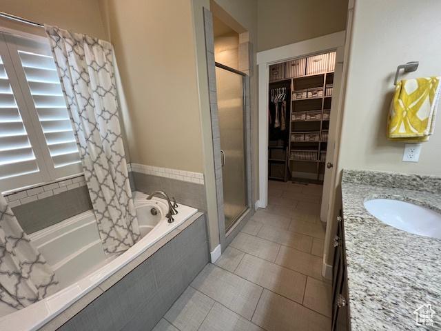 115 E 8469 S, Sandy, UT 84070 - full bathroom featuring a shower stall, tiled tub, vanity, tile patterned floors, and a spacious closet