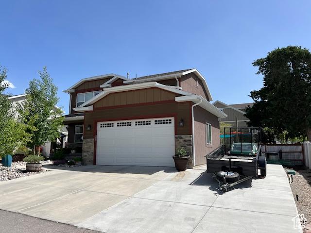 115 E 8469 S, Sandy, UT 84070 - view of front of home featuring stone siding, driveway, and an attached garage