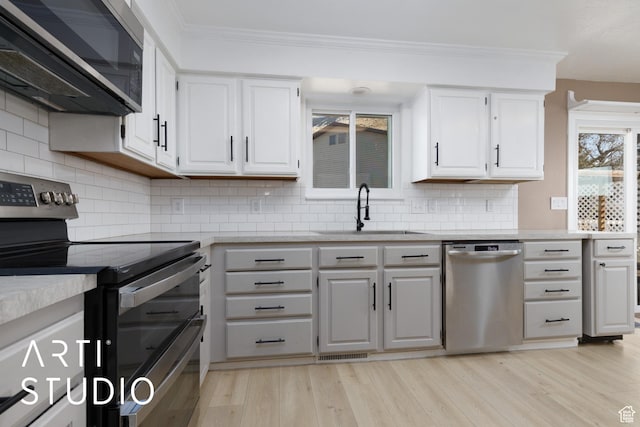 1280 N Gramercy Ave, Ogden, UT 84404 - kitchen with appliances with stainless steel finishes, a sink, white cabinetry, crown molding, and light countertops