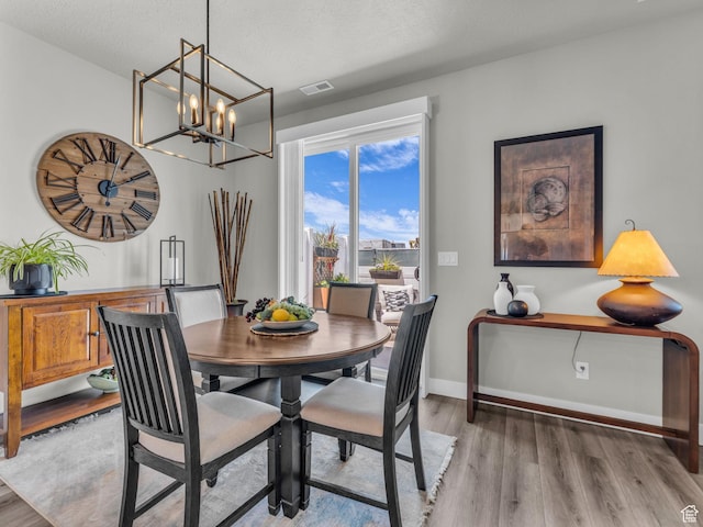 1136 W 1810 S, Orem, UT 84058 - dining area with light wood-style flooring, a chandelier, baseboards, and a textured ceiling
