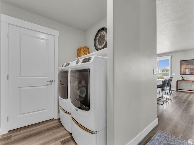 1136 W 1810 S, Orem, UT 84058 - laundry room with washing machine and clothes dryer, light wood-type flooring, baseboards, and a textured ceiling