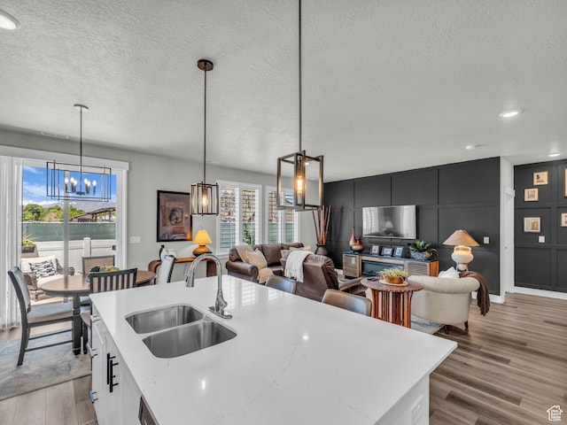 1136 W 1810 S, Orem, UT 84058 - kitchen featuring a sink, a chandelier, a textured ceiling, light wood-style floors, and hanging light fixtures