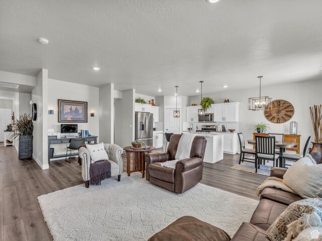 1136 W 1810 S, Orem, UT 84058 - living room featuring dark wood-style floors, a chandelier, recessed lighting, a textured ceiling, and baseboards