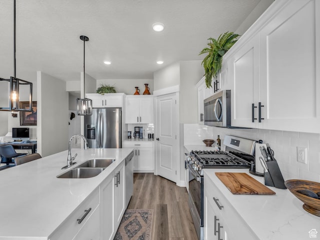 1136 W 1810 S, Orem, UT 84058 - kitchen featuring stainless steel appliances, a sink, white cabinets, wood finished floors, and backsplash