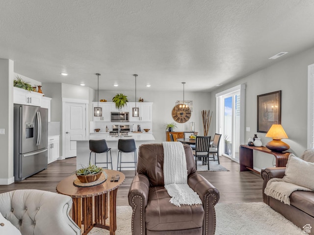 1136 W 1810 S, Orem, UT 84058 - living area featuring dark wood-type flooring, a chandelier, a textured ceiling, and recessed lighting