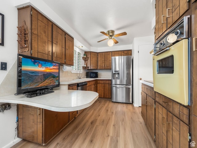 686 Idaho Ave, Provo, UT 84606 - kitchen featuring appliances with stainless steel finishes, a peninsula, light countertops, light wood-style flooring, and ceiling fan