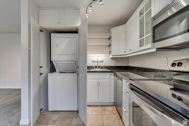 1255 E 200 S # 10, Salt Lake City, UT 84102 - kitchen with appliances with stainless steel finishes, stacked washer and clothes dryer, a sink, white cabinets, and glass insert cabinets