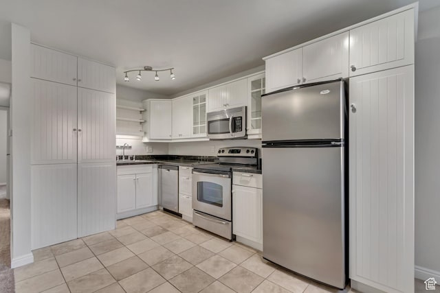 1255 E 200 S # 10, Salt Lake City, UT 84102 - kitchen with appliances with stainless steel finishes, dark countertops, open shelves, light tile patterned floors, and a sink