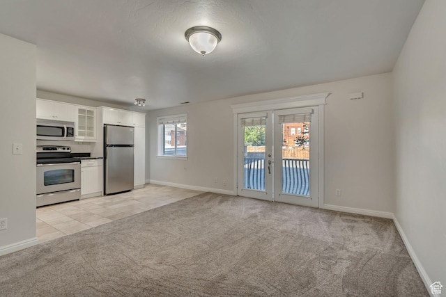1255 E 200 S # 10, Salt Lake City, UT 84102 - kitchen with stainless steel appliances, light colored carpet, glass insert cabinets, white cabinets, and french doors