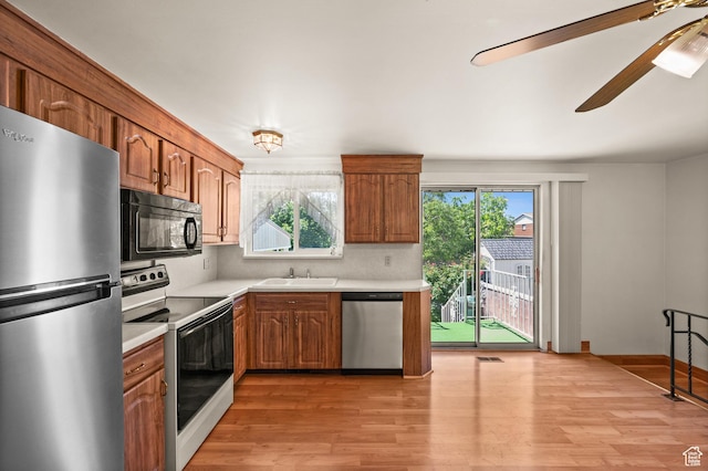 3279 W Crestfield, West Valley City, UT 84119 - kitchen featuring appliances with stainless steel finishes, light countertops, light wood-type flooring, and brown cabinetry
