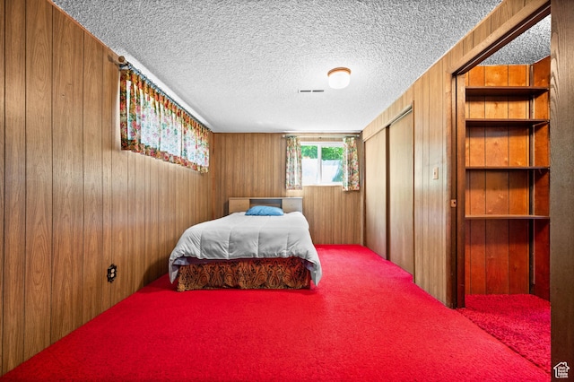 3279 W Crestfield, West Valley City, UT 84119 - bedroom featuring wood walls, carpet flooring, a closet, and a textured ceiling