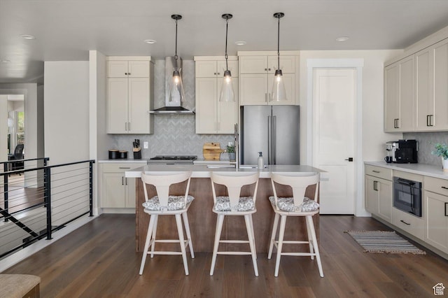 11661 N Shoreline Dr, Hideout, UT 84036 - kitchen featuring wall chimney range hood, freestanding refrigerator, backsplash, dark wood finished floors, and recessed lighting