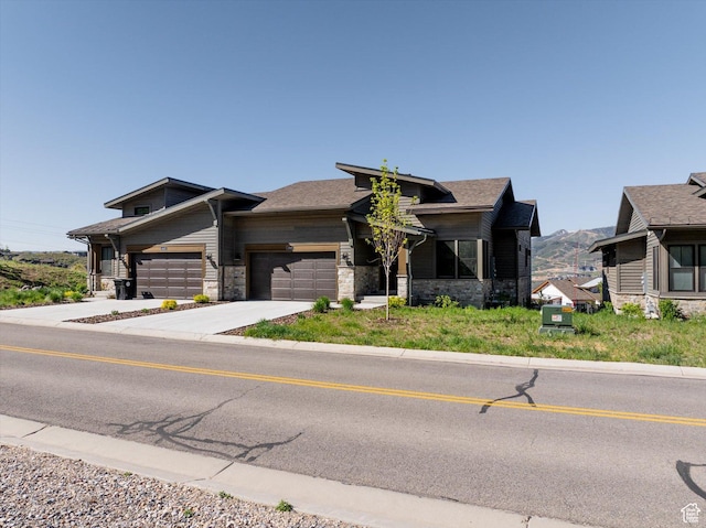 11661 N Shoreline Dr, Hideout, UT 84036 - view of front of home featuring stone siding, a garage, concrete driveway, and a mountain view