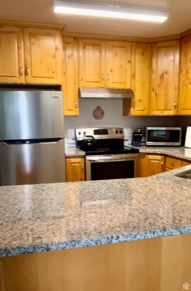 595 S Main St Unit 26, Kamas, UT 84036 - kitchen with stainless steel appliances, under cabinet range hood, and light stone countertops