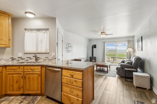595 S Main St Unit 26, Kamas, UT 84036 - kitchen featuring dishwasher, a sink, a wood stove, open floor plan, and light wood-type flooring
