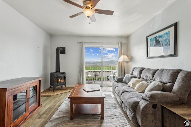 595 S Main St Unit 26, Kamas, UT 84036 - living area featuring wood finished floors, a wood stove, a ceiling fan, and baseboards