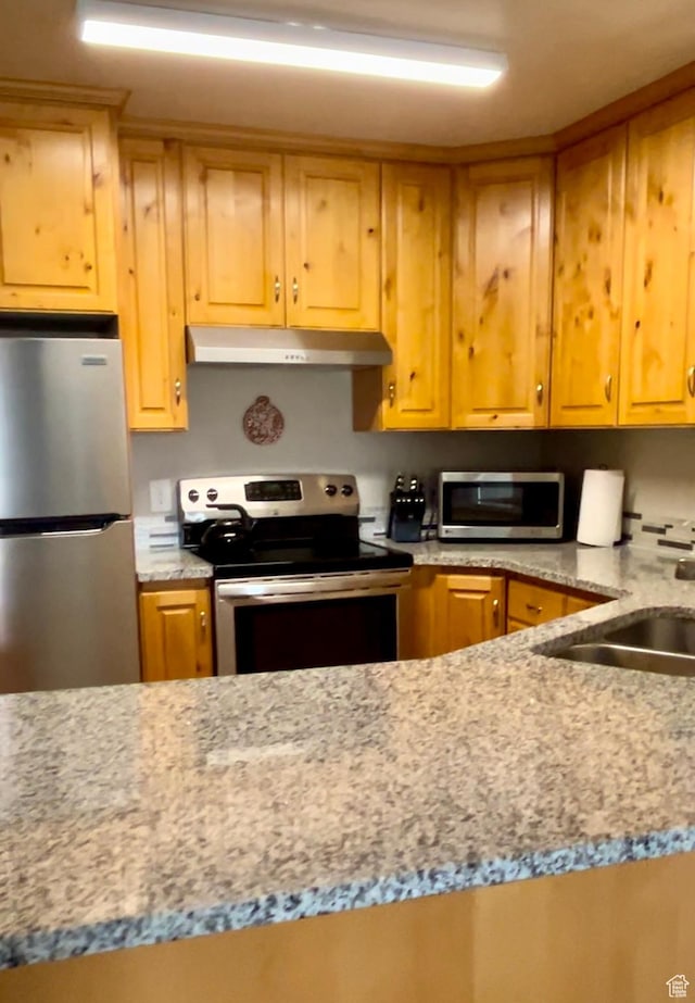 595 S Main St Unit 26, Kamas, UT 84036 - kitchen with stainless steel appliances, under cabinet range hood, light stone counters, and a sink