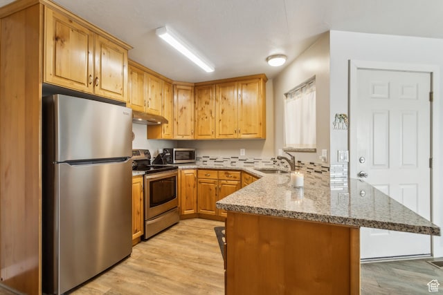 595 S Main St Unit 26, Kamas, UT 84036 - kitchen with appliances with stainless steel finishes, a peninsula, a sink, under cabinet range hood, and light stone counters
