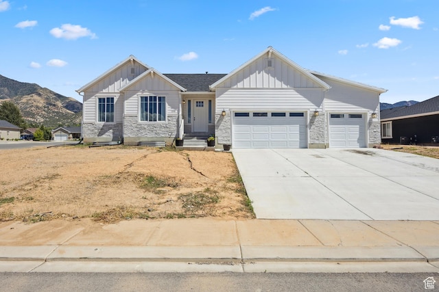 1228 N 100 E, Nephi, UT 84648 - view of front facade featuring board and batten siding, a garage, stone siding, and driveway