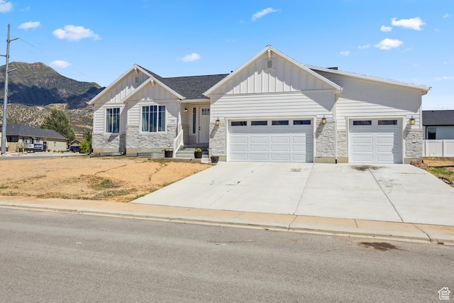 1228 N 100 E, Nephi, UT 84648 - view of front of house with board and batten siding, stone siding, a mountain view, and a garage
