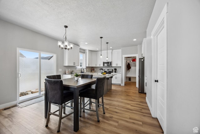 1228 N 100 E, Nephi, UT 84648 - dining area with a chandelier, light wood finished floors, recessed lighting, a textured ceiling, and baseboards