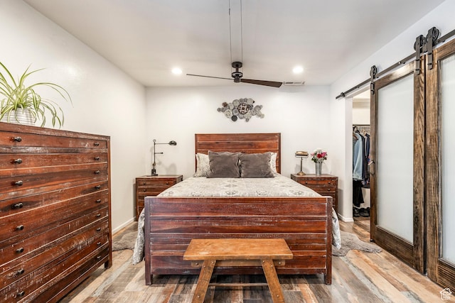 4097 S 670 E Unit C, Murray, UT 84107 - bedroom featuring a barn door, light wood finished floors, a spacious closet, recessed lighting, and a ceiling fan