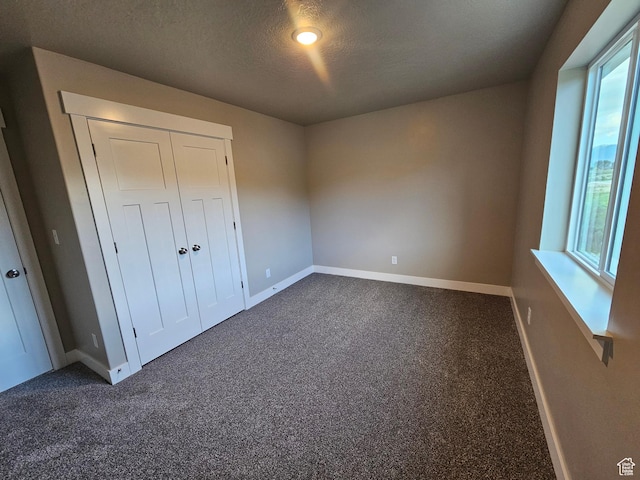 454 N 500 E Lot 3, Salem, UT 84653 - unfurnished bedroom featuring baseboards, dark carpet, a textured ceiling, and a closet