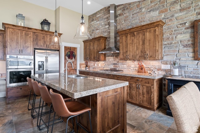 10371 N Sightline Cir, Hideout, UT 84036 - kitchen featuring stainless steel appliances, wall chimney range hood, a sink, decorative backsplash, and brown cabinetry