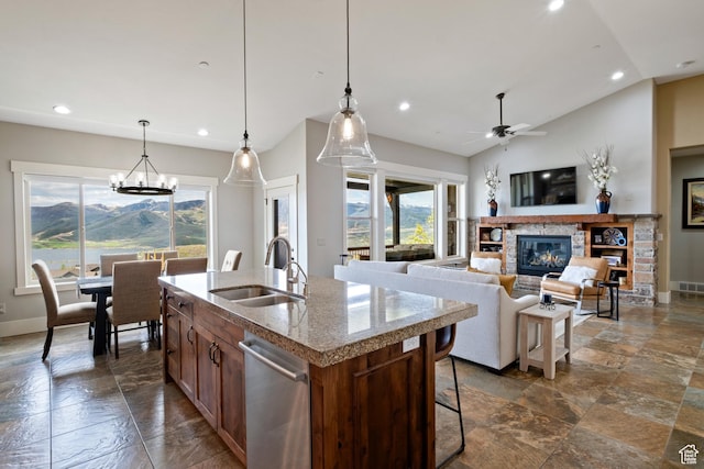 10371 N Sightline Cir, Hideout, UT 84036 - kitchen with stone tile floors, recessed lighting, a fireplace, a kitchen island with sink, and a sink