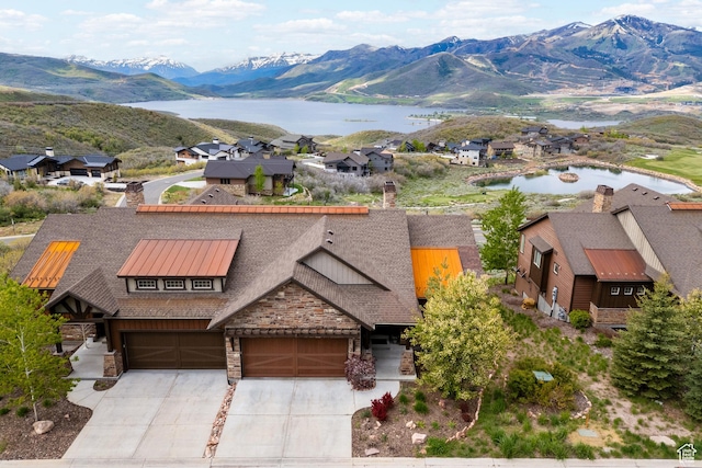 10371 N Sightline Cir, Hideout, UT 84036 - view of front facade with a chimney, stone siding, a water and mountain view, and concrete driveway