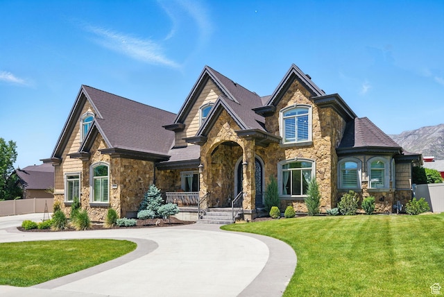 62 W 225 N, Lindon, UT 84042 - view of front of home with stone siding, a porch, curved driveway, and a shingled roof