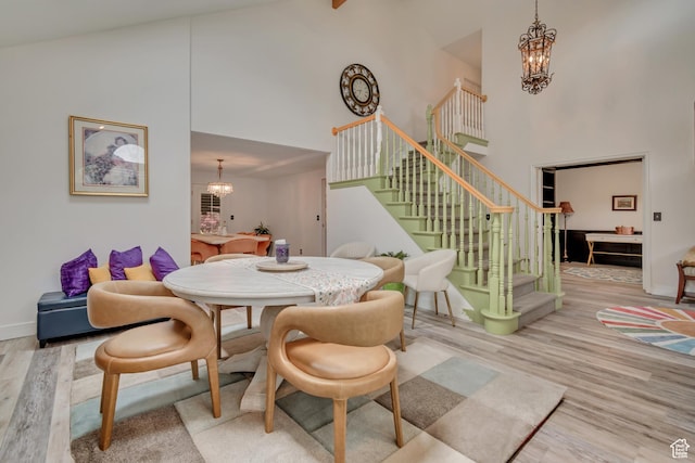 11198 S Wyngate Ln E, Sandy, UT 84092 - dining area featuring a chandelier, high vaulted ceiling, stairway, wood finished floors, and baseboards