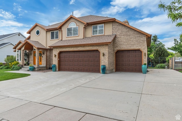 11198 S Wyngate Ln E, Sandy, UT 84092 - view of front of property with driveway, an attached garage, stucco siding, and brick siding