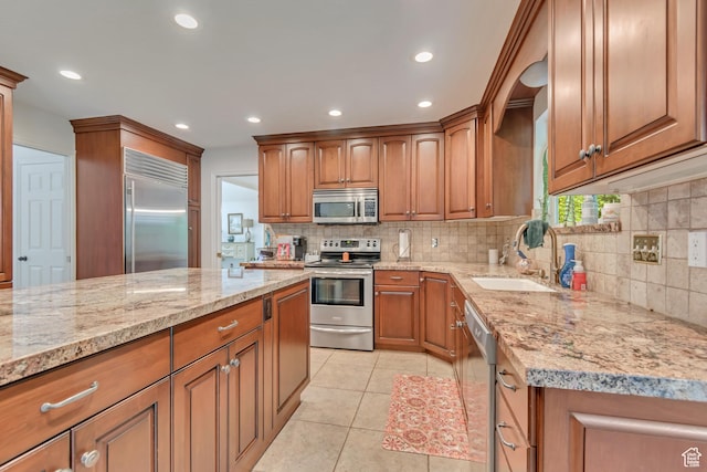 11198 S Wyngate Ln E, Sandy, UT 84092 - kitchen with appliances with stainless steel finishes, a sink, brown cabinetry, backsplash, and recessed lighting