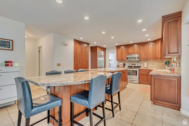11198 S Wyngate Ln E, Sandy, UT 84092 - kitchen featuring appliances with stainless steel finishes, a kitchen island, light tile patterned floors, backsplash, and recessed lighting